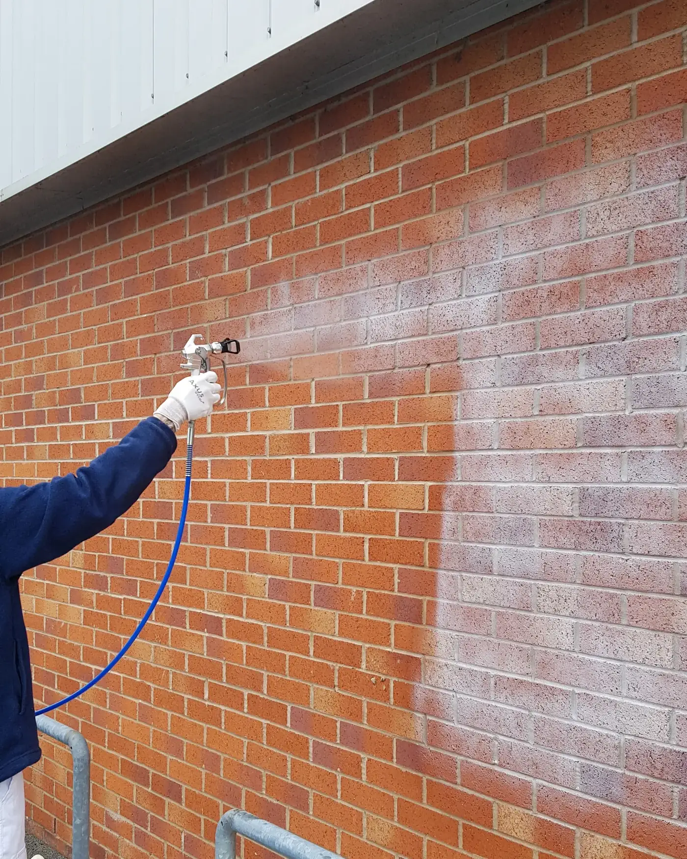 Operative spray-applying treatment to a brick wall