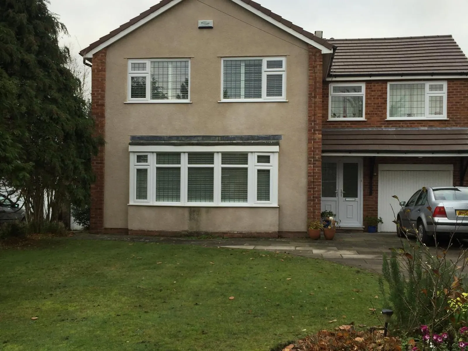 A detached house with dull, weathered render