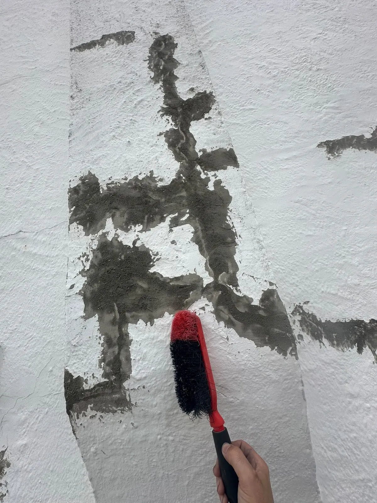 Repair filler being worked into a crack with a brush