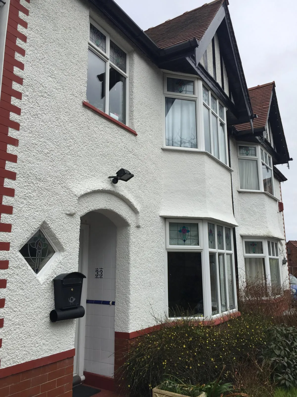 1930s semi with fresh white render and red brick detailing
