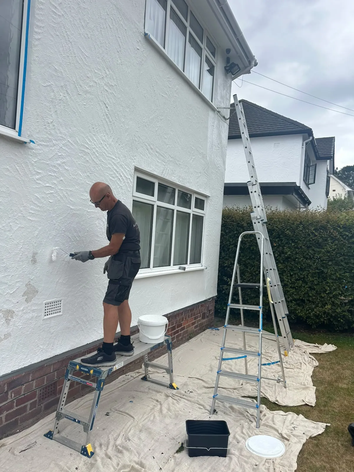 One of our applicators coating a rendered wall from a work platform