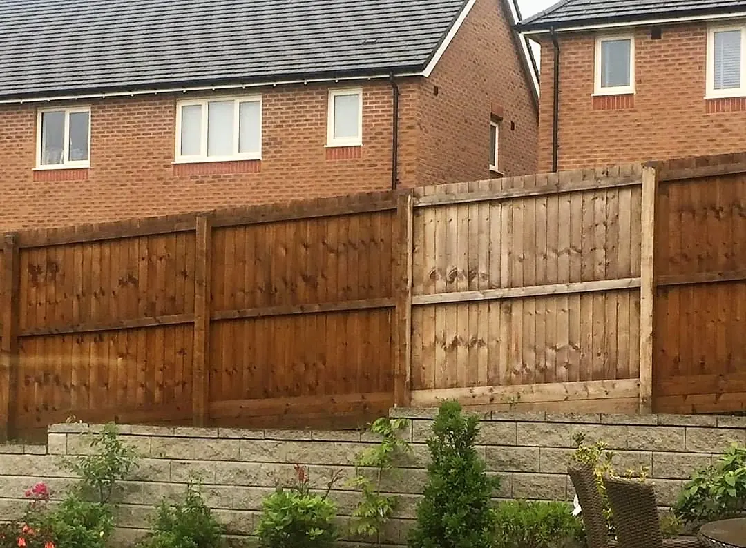 A garden fence, part faded and part fresh timber